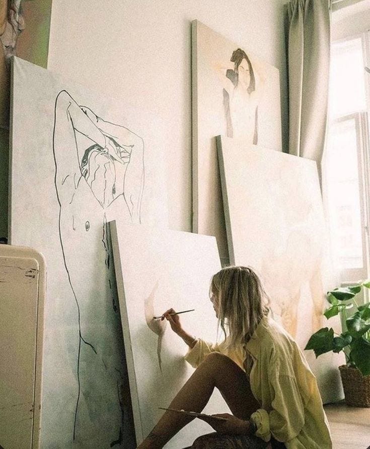 This may contain: a woman is sitting on the floor drawing