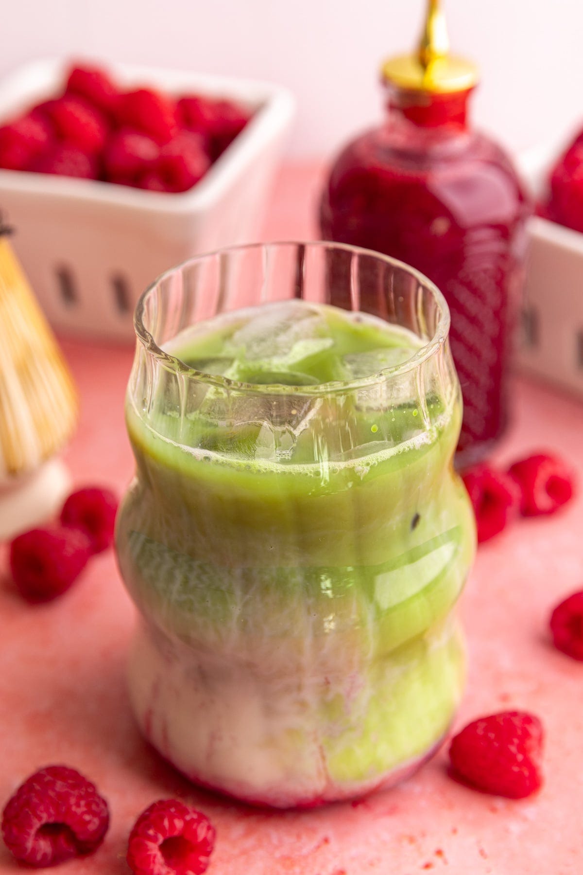 An iced raspberry matcha latte, stirred.