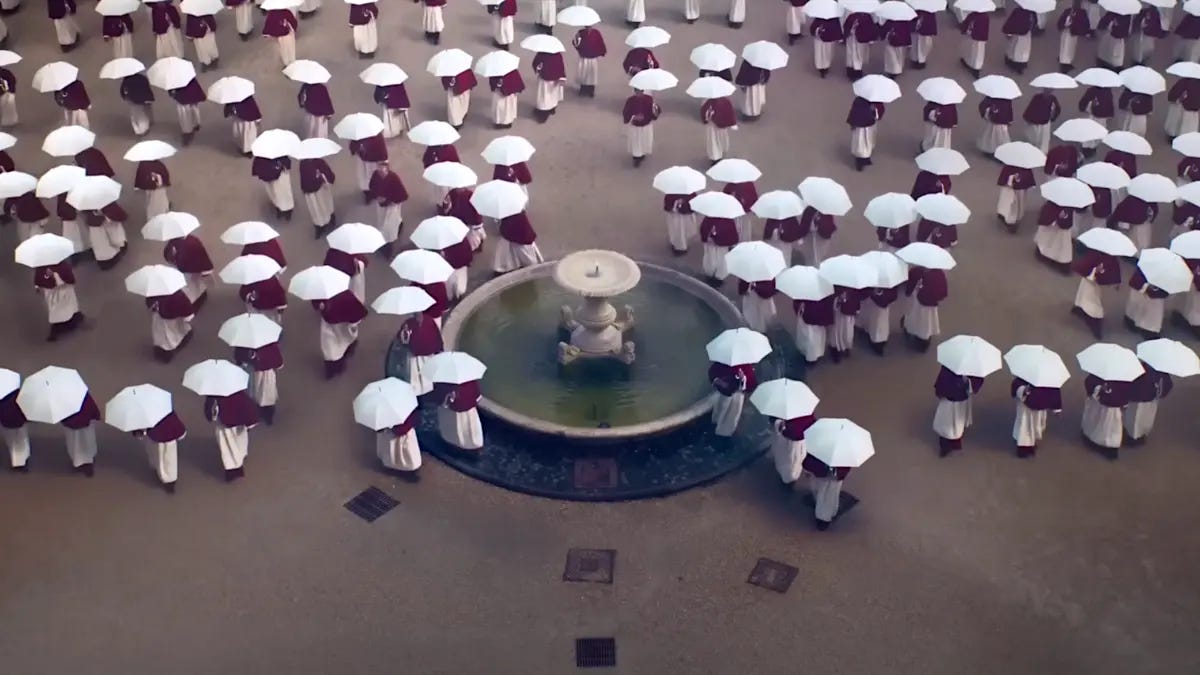 Plan du film Conclave où on voit les cardinaux d'en haut, chacun portant un parapluie blanc, l'image est très saisissante esthétiquement.