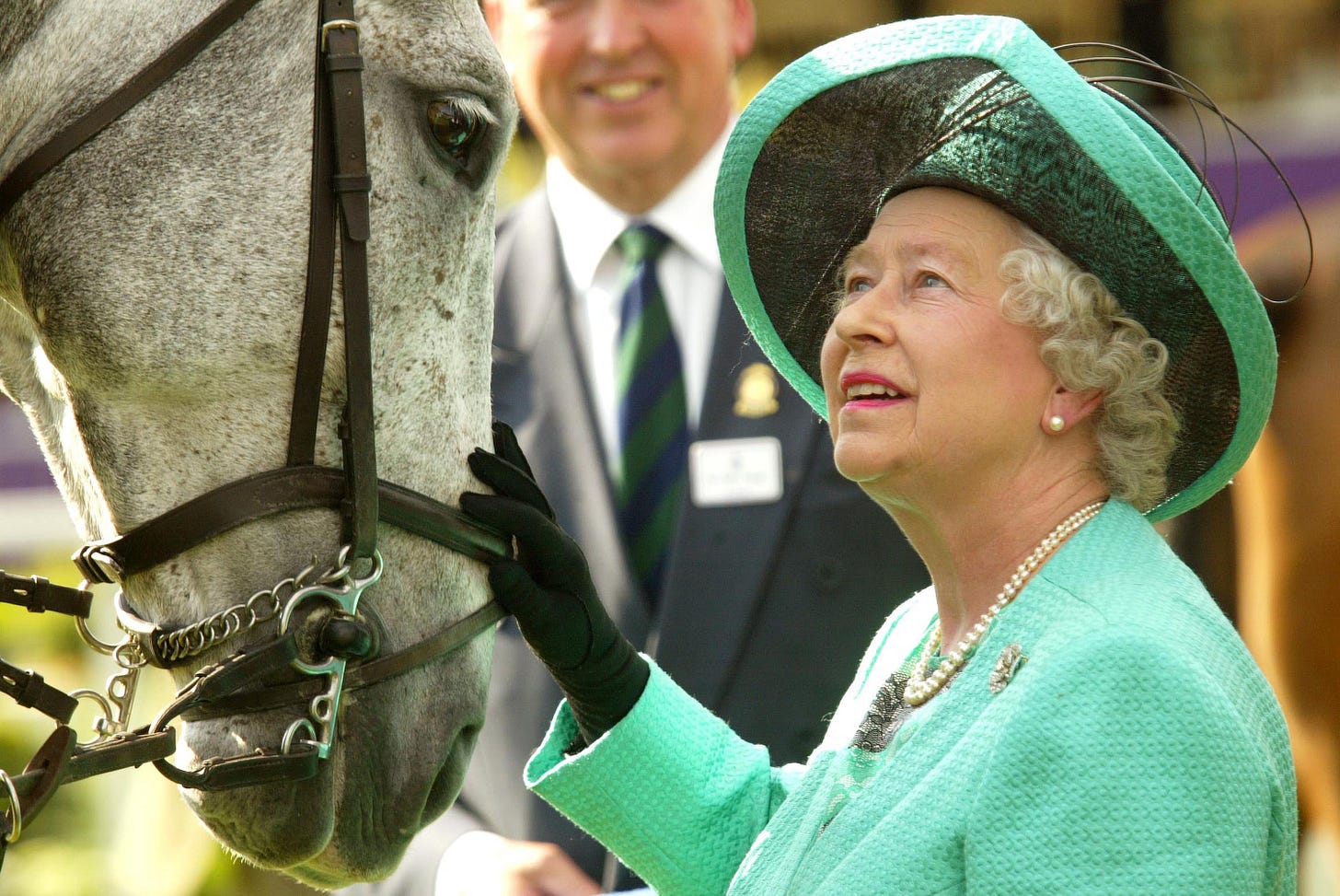 Queen Elizabeth patting a horse
