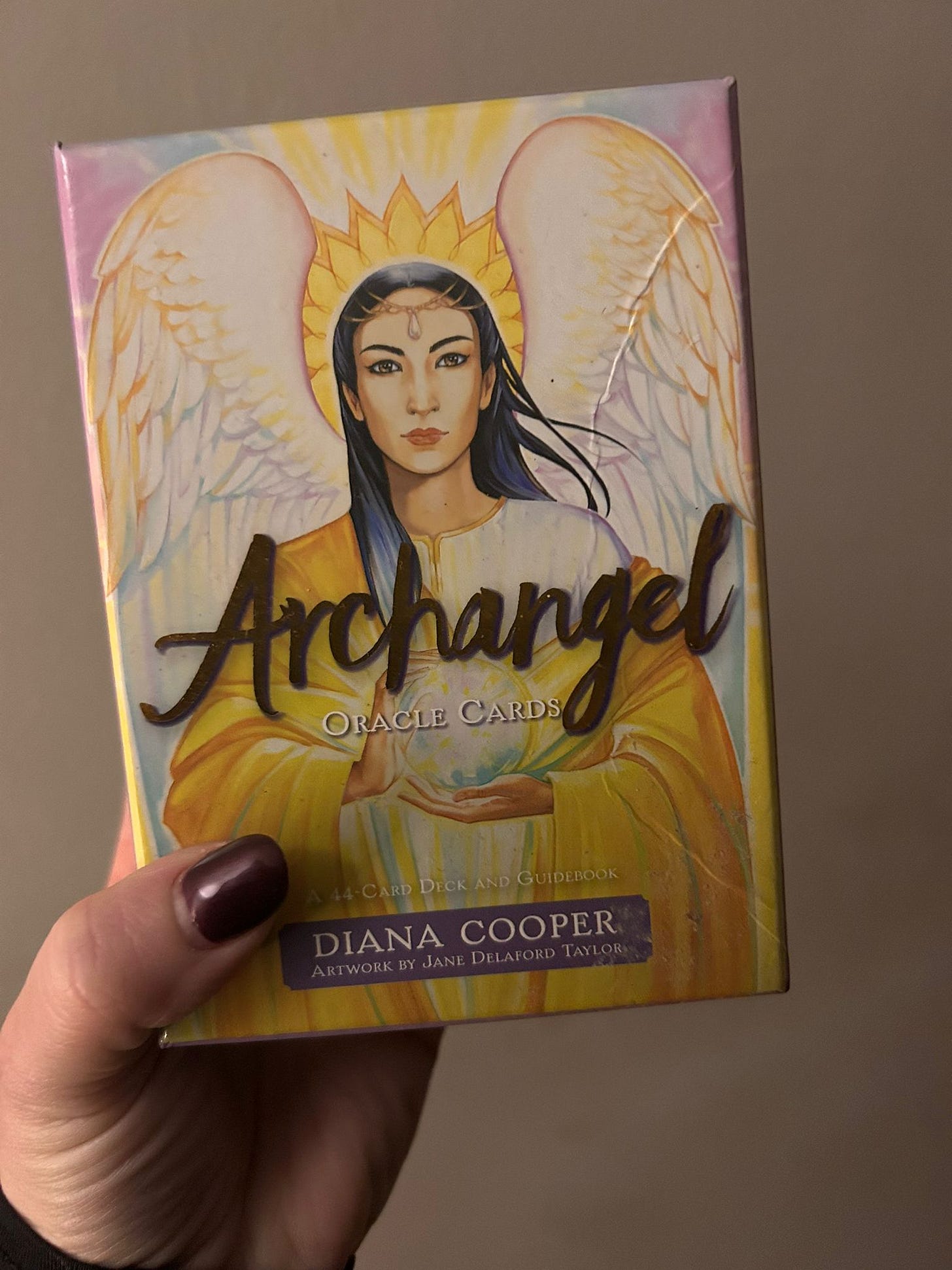 Archangel Oracle Cards deck by Diana Cooper held in hand - spiritual card deck referenced in discussion of early divination influences before tarot practice. Archangel Oracle Cards deck by Diana Cooper held in hand - spiritual card deck referenced in discussion of early divination influences before tarot practice.