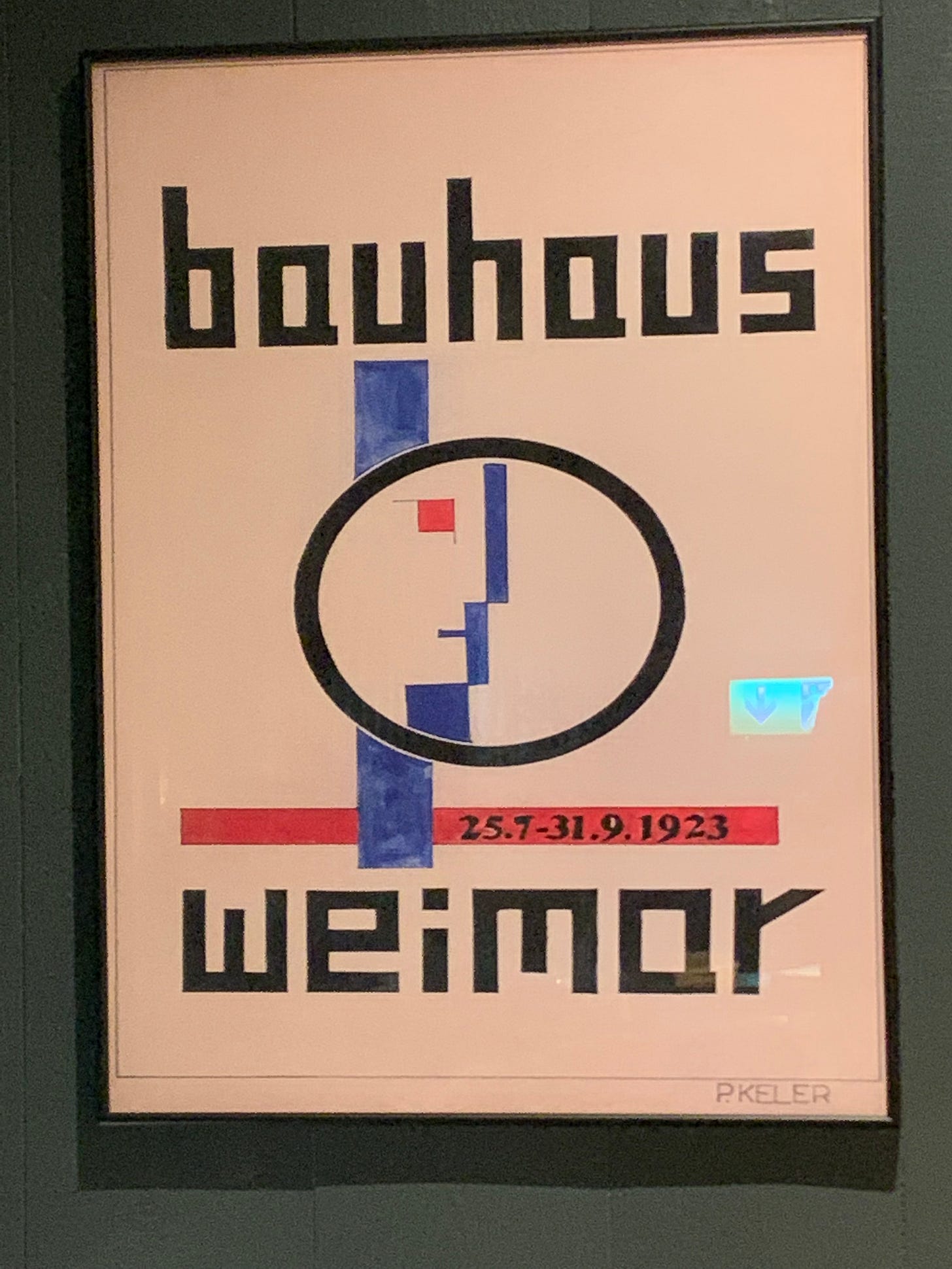 A reproduction of the Bauhaus exhibition poster framed on a dark wall A reproduction of the Bauhaus exhibition poster framed on a dark wall
