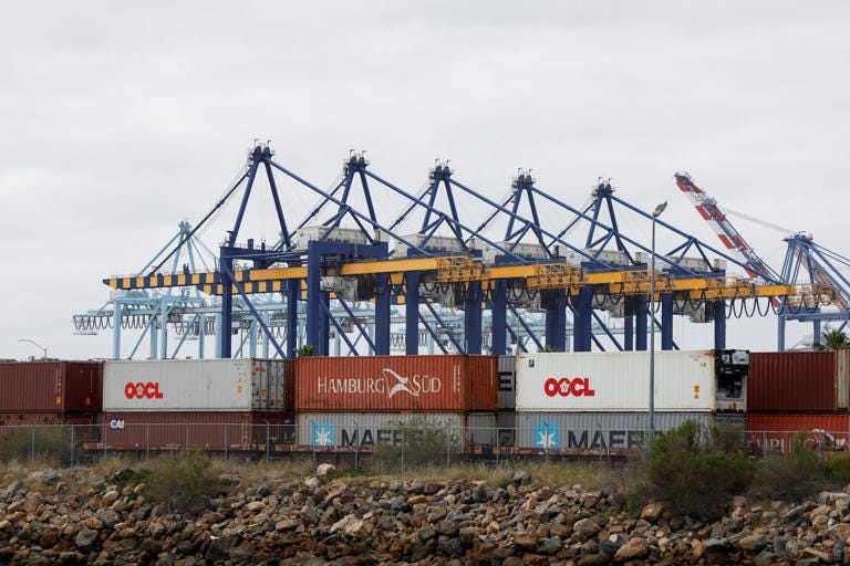 Shipping containers wait to be transported along a railroad at the port of Los Angeles in Long Beach, California, on March 10, 2026.