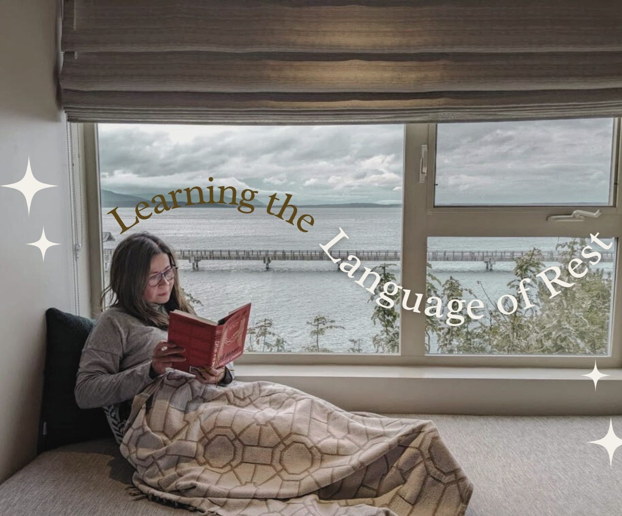 A female with glasses comfortably reading a book in a room overlooking a body of water A female with glasses comfortably reading a book in a room overlooking a body of water