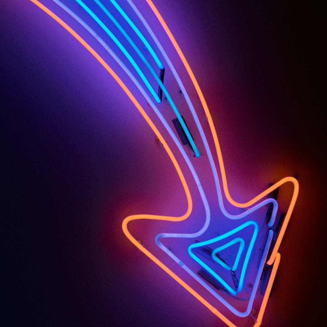 A neon sign with an arrow pointing to the right