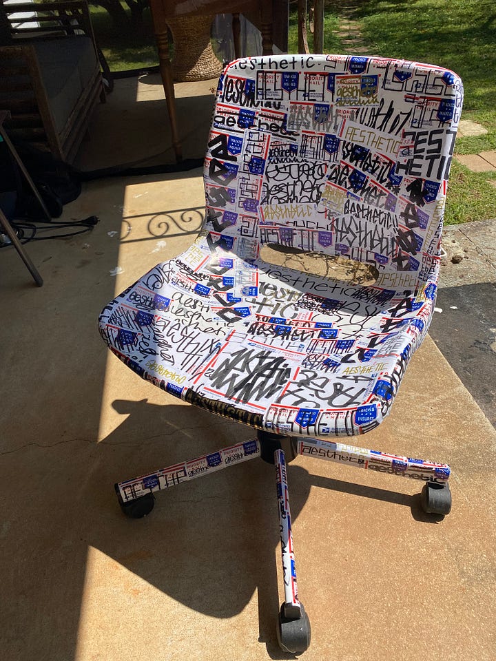 Black, white, and pink "DOWN" on a graffiti wall, over 100 handwritten "aesthetic" stickers on a rolling chair, "Like" painted in blue, yellow, and white facing up and down, and "motherquake" painted in black on a yellow square.