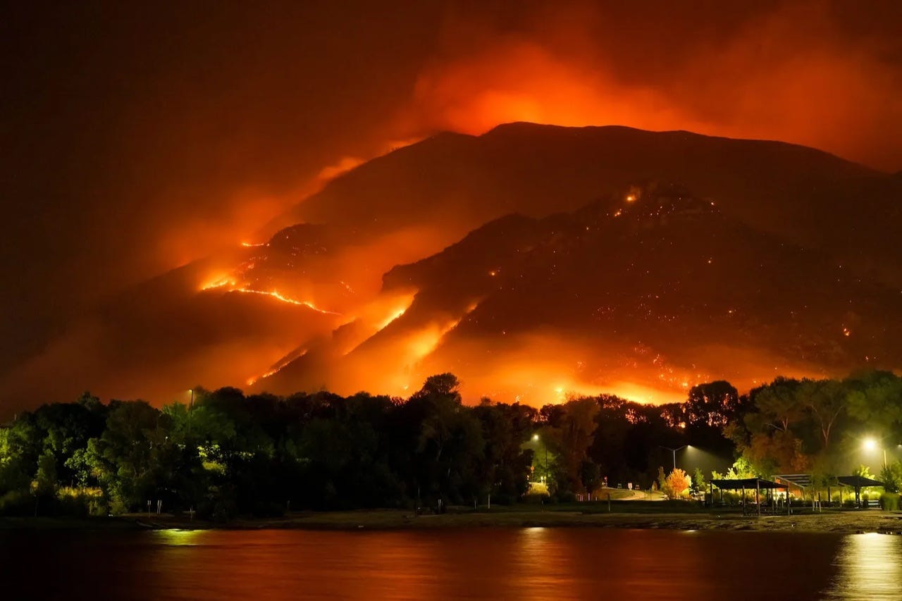 fire burning hillside over town