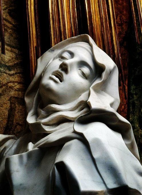 This may contain: a statue of a woman with her eyes closed in front of some gold and white curtains