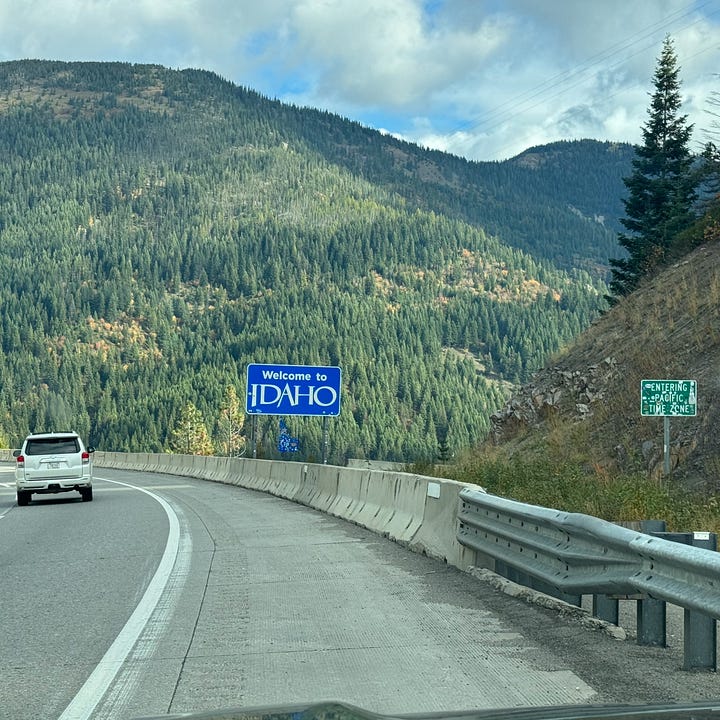 State line sign in Idaho and pictures of lake Coeur D'Alene with water and trees