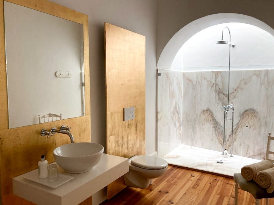 Goldenes BAdezimmer mit großer Marmordusche