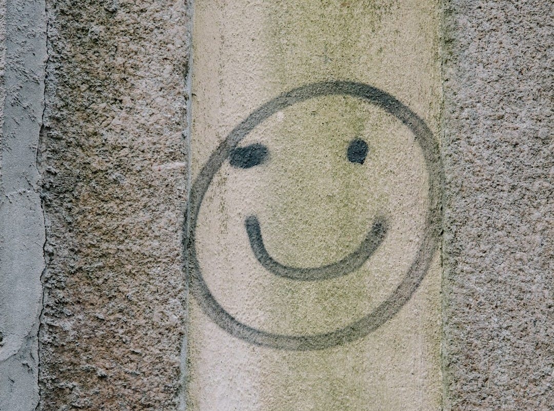 A smiley face painted on a cement wall