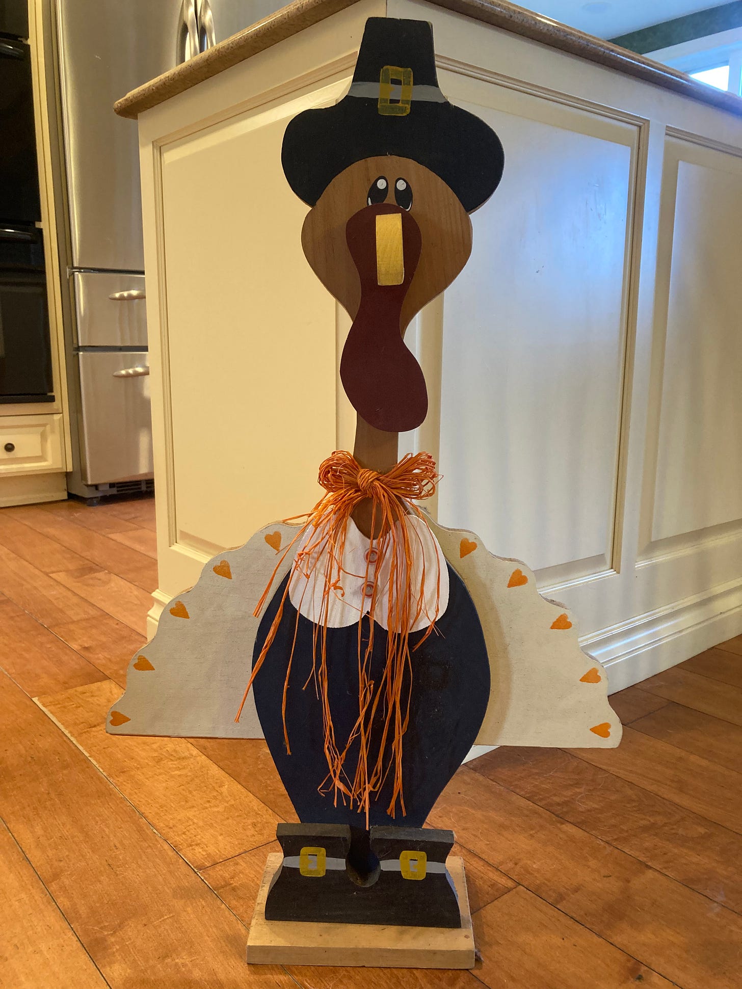 A wooden life-sized cutout of a turkey stands in a kitchen A wooden life-sized cutout of a turkey stands in a kitchen