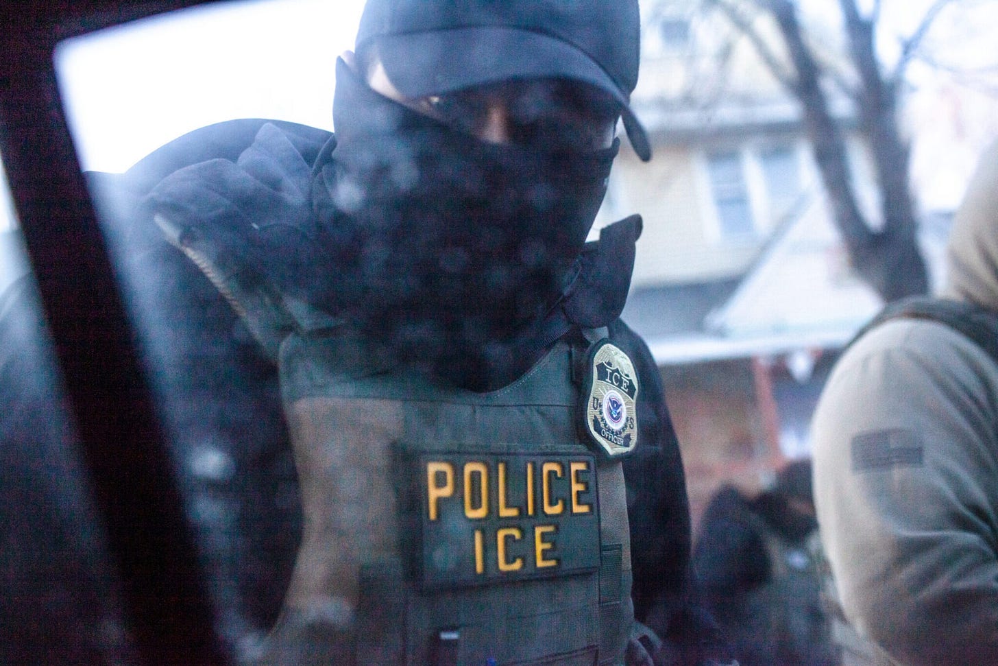 A masked ICE agent knocks on the window of an observer's car in Minneapolis, Minn., Jan. 12, 2026 (Photo by Nicole Neri/Minnesota Reformer)