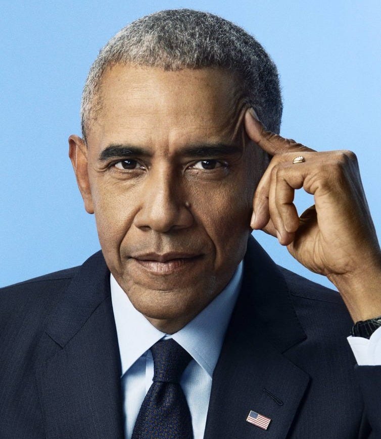 Middle-aged man in dark suit and blue tie with American flag lapel pin against blue background