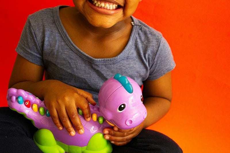 Smiling Child with toy dinosaur
