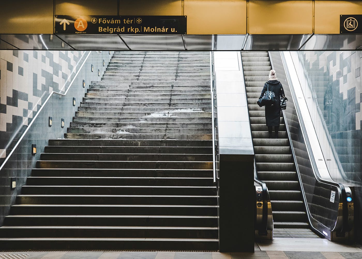 Photo of a woman riding the escalator in a train station Photo of a woman riding the escalator in a train station
