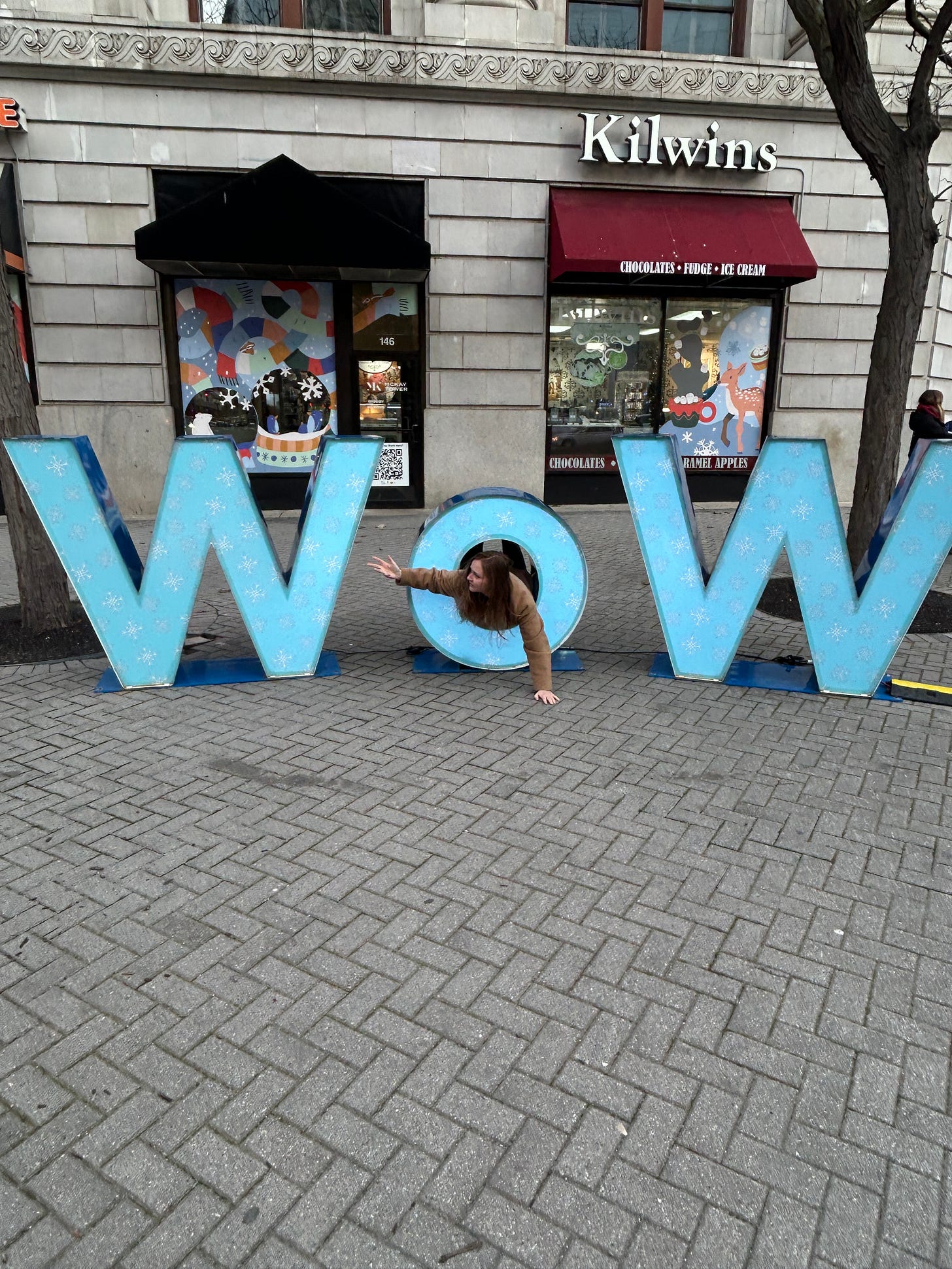 A woman caught in the "o" of a giant "WOW" sign in Grand Rapids