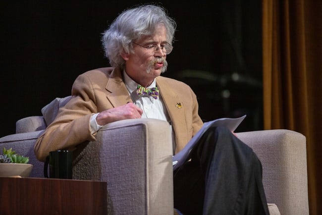 Art Cullen lors d'une conférence, lunettes sur le nez, cheveux gris, grosses moustaches pendantes.