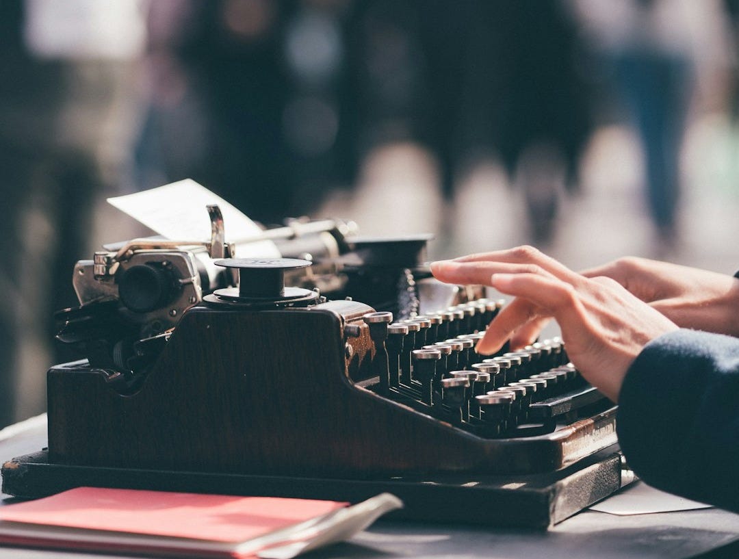 person using black typewriter person using black typewriter