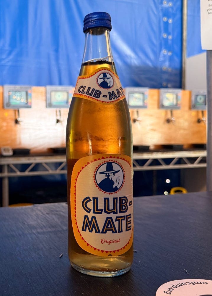 A bottle of club mate sits on the bar at EMF camp. It's all mine.