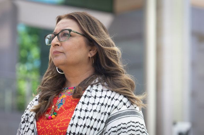 A woman looks into the distance she is wearing a black and white scarf A woman looks into the distance she is wearing a black and white scarf