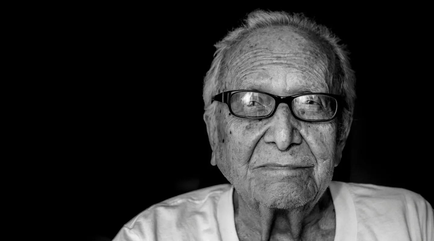 Hombre de tercera edad viendo hacia la cámara.