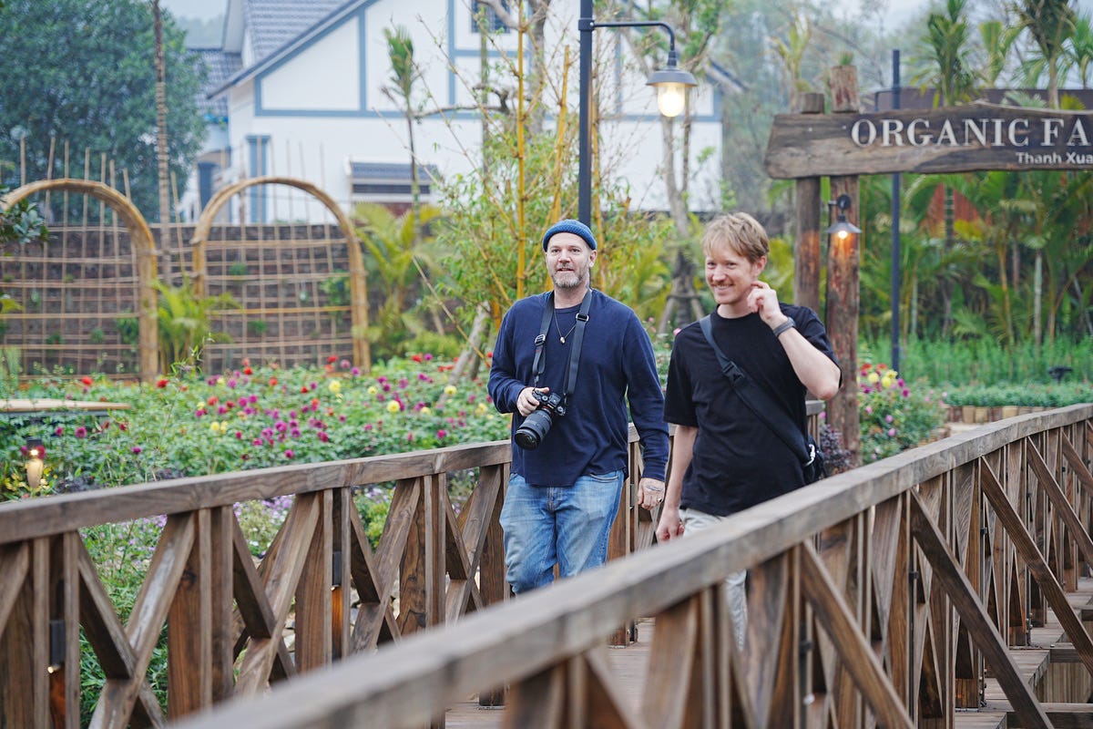 Justin Mott and a cinematographer walking together on a wooden bridge