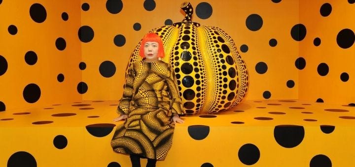 Yayoi Jusama in front of a large pumpkin sculpture Yayoi Jusama in front of a large pumpkin sculpture