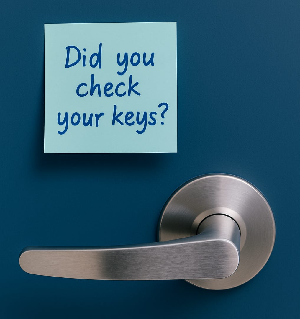 Modern door handle on a deep blue door with a sticky note that says ‘Did you check your keys?’