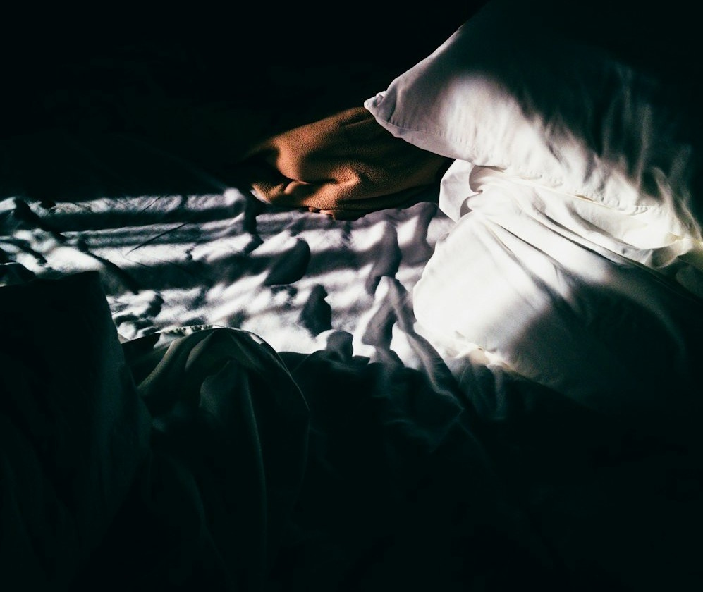 gray throw pillow on gray bedspread