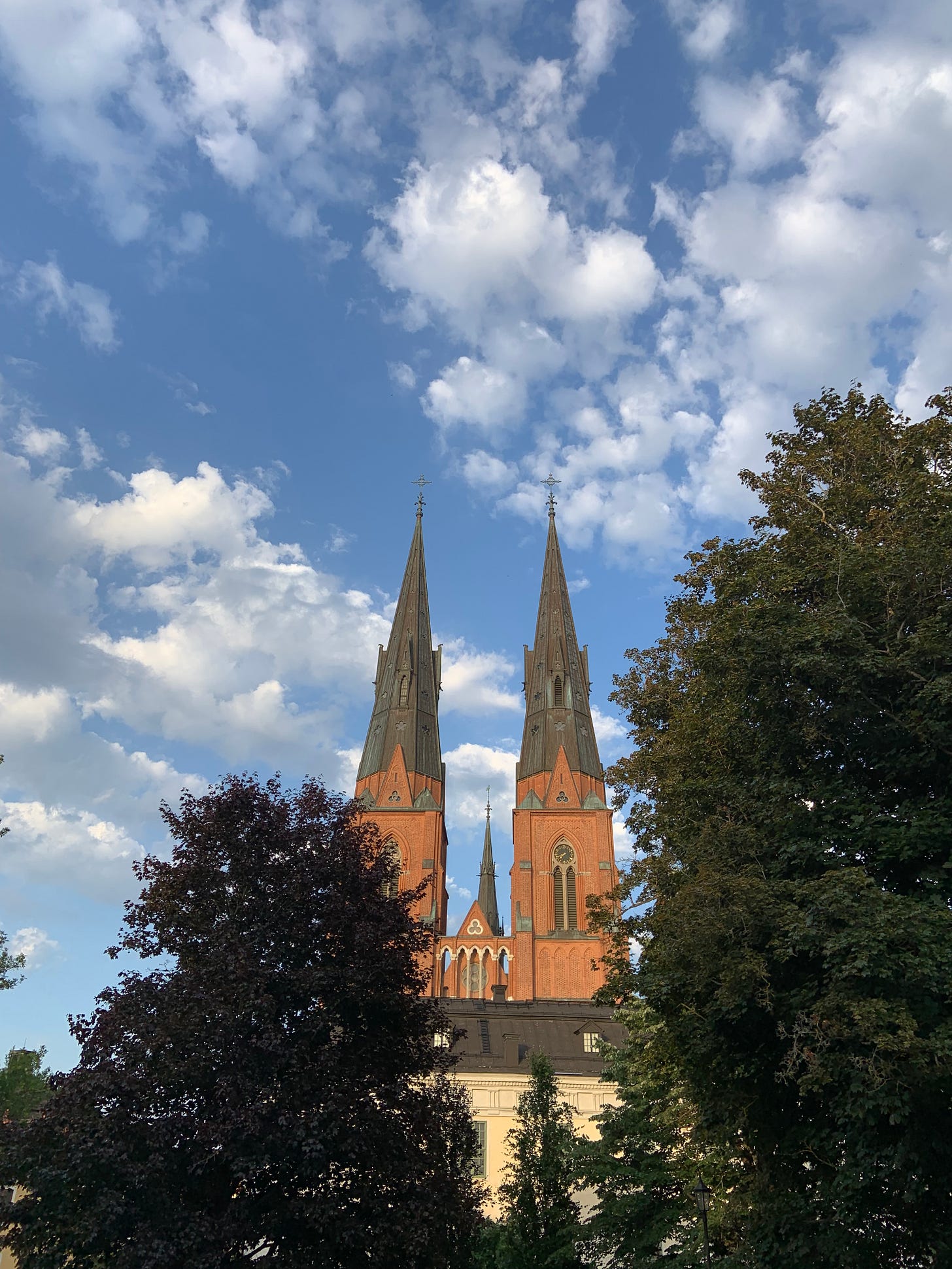 photo of a cathedral, over clouds and a blue sky