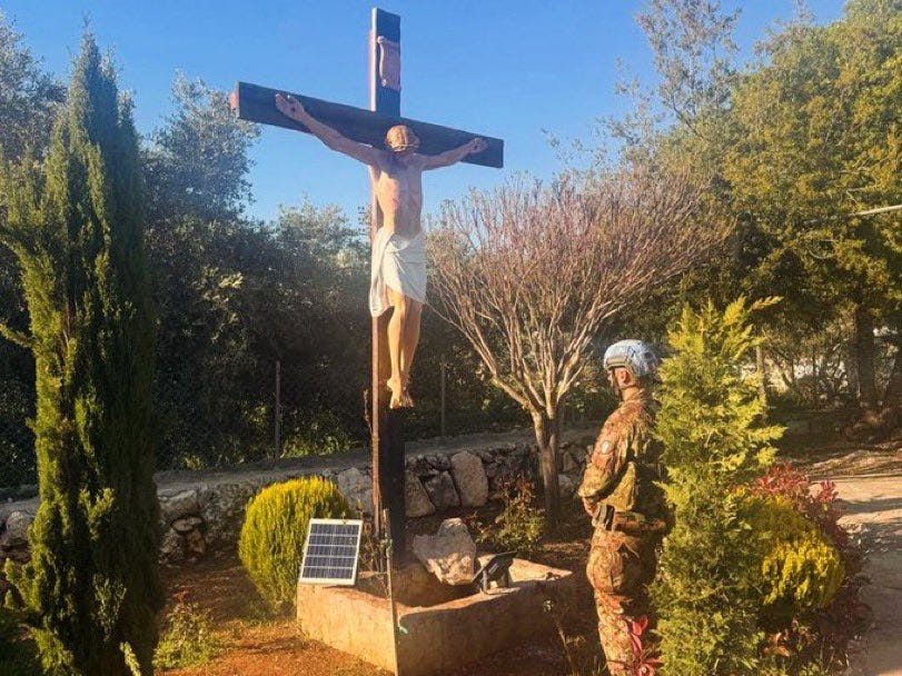 An Italian UNIFIL peacekeeper stands in prayer after helping restore the crucified Christ statue in Debel, southern Lebanon.