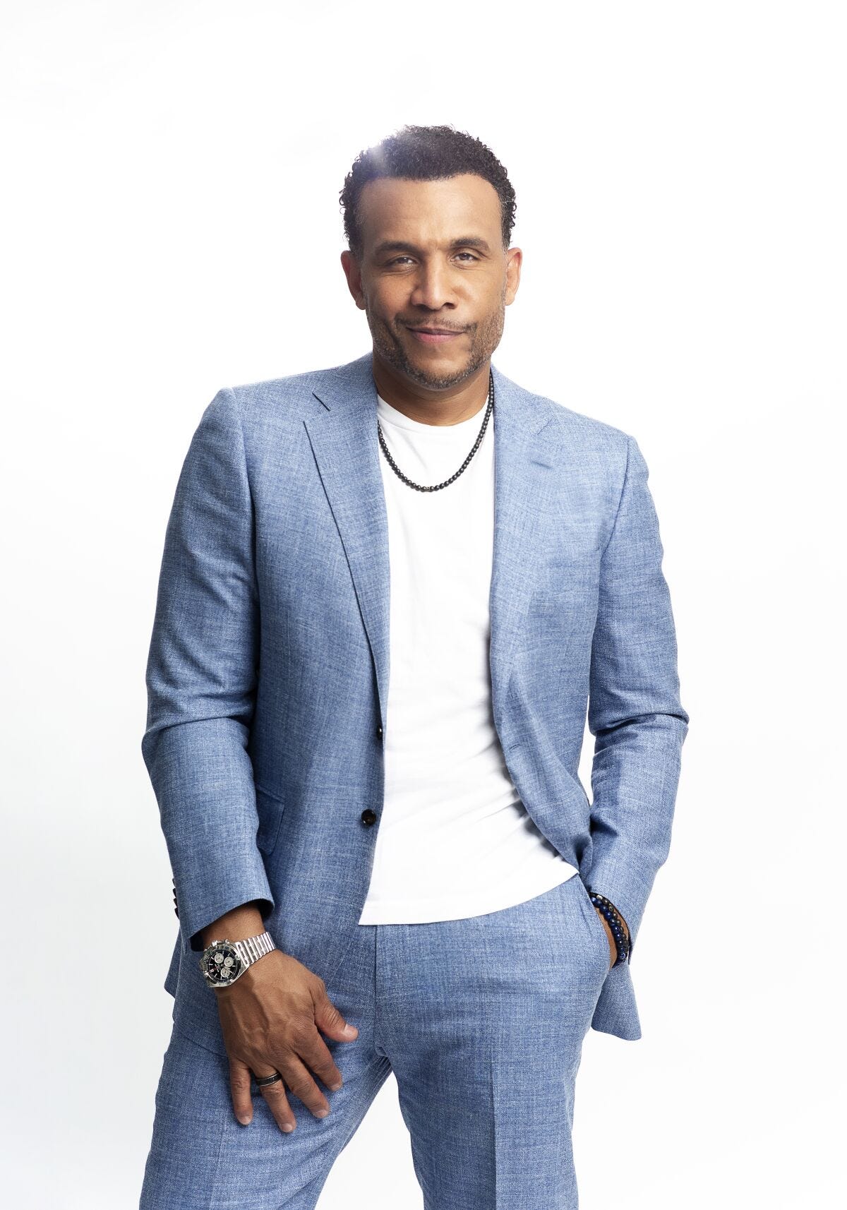 A portrait of a smiling man wearing a blue suit