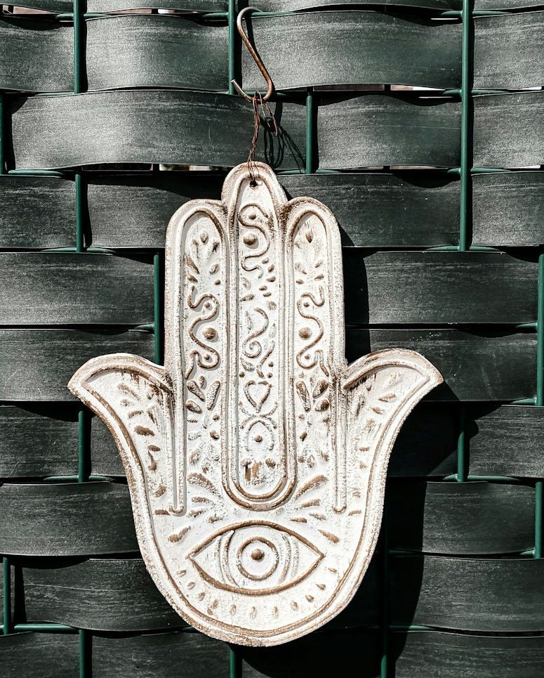 a hamsa hanging on a wall in front of a woven wall a hamsa hanging on a wall in front of a woven wall