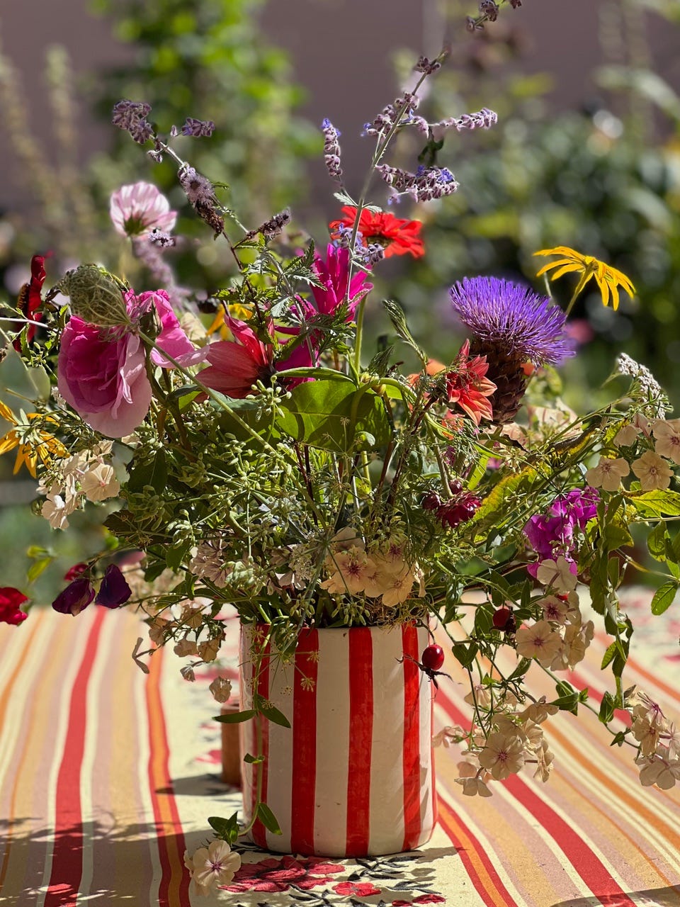 brightly coloured homegrown flowers in a pretty jug on a table