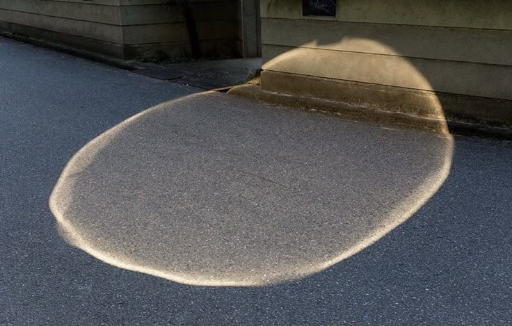 This may contain: the shadow of a skateboarder is seen in front of a house
