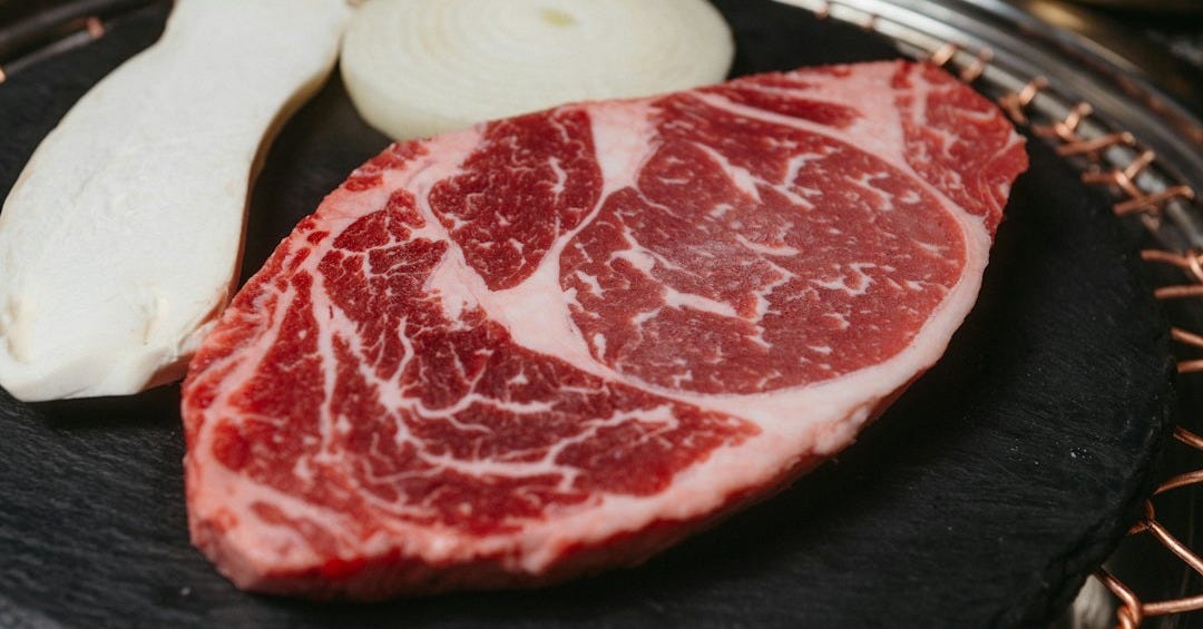 a piece of meat sitting on top of a black plate