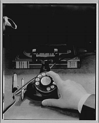 a black and white photo of a man's hand dialing a rotary phone a black and white photo of a man's hand dialing a rotary phone
