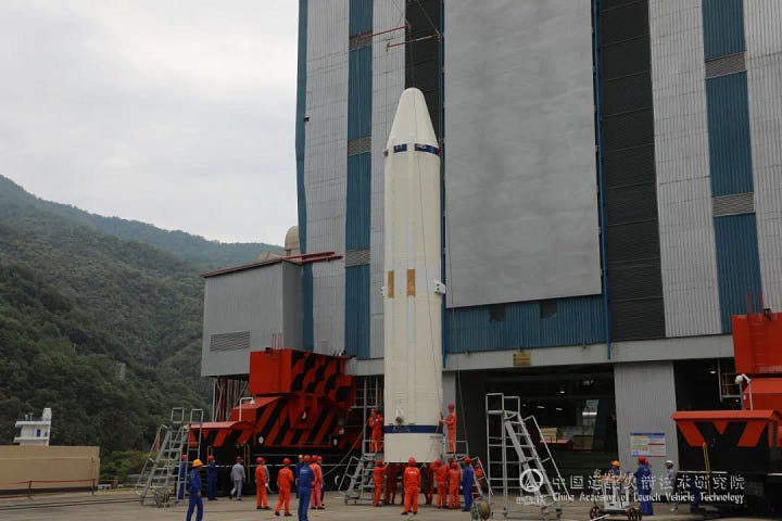 The Long March 3B/E's booster and fairing being prepared for the mission, and the ChinaSat-9C satellite being hoisted toward the top of the vehicle.