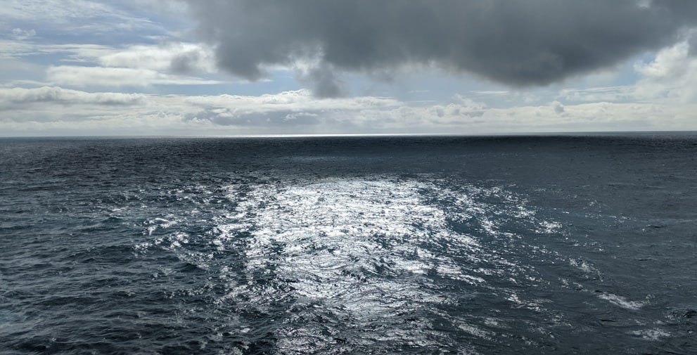a large body of water under a cloudy sky