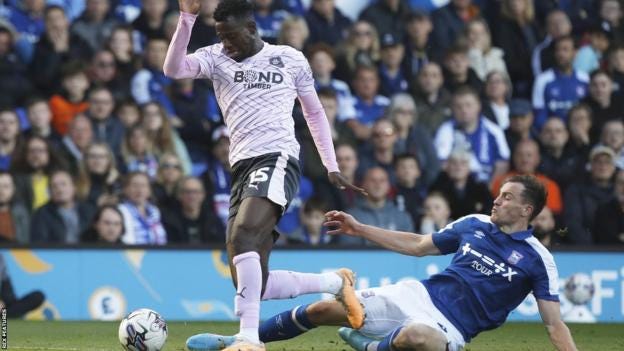 George Edmundson attempting to tackle Mustapaha Bundu on the edge of Ipswich's penalty area, Ipswich v Plymouth, October 2022