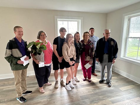 Pictures of a rebuilt house and the people who came by for the grand opening.