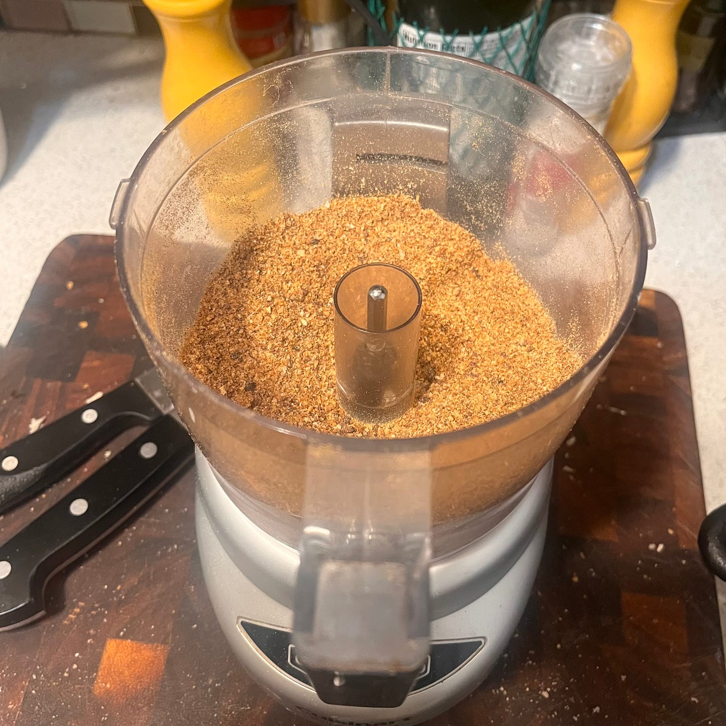 toasted breadcrumbs inside a food processor on top of a wooden cutting board toasted breadcrumbs inside a food processor on top of a wooden cutting board