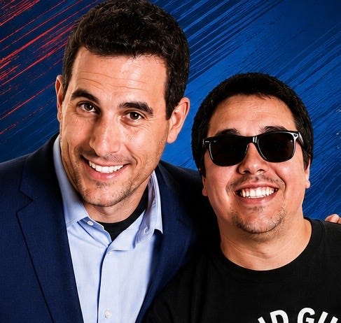 Promotional photo of Scott Ward and Blind Guy Comedy (J.R. Bjornson) smiling together against a blue textured background. Scott Ward is wearing a navy blazer over a light blue dress shirt, while J.R. Bjornson is wearing black sunglasses and a black Blind Guy Comedy T-shirt. The image promotes the performers' Alberta theatre tour, featuring clean stand-up comedy by J.R. Bjornson followed by Scott Ward's interactive Comedy Hypnosis Show. Promotional photo of Scott Ward and Blind Guy Comedy (J.R. Bjornson) smiling together against a blue textured background. Scott Ward is wearing a navy blazer over a light blue dress shirt, while J.R. Bjornson is wearing black sunglasses and a black Blind Guy Comedy T-shirt. The image promotes the performers' Alberta theatre tour, featuring clean stand-up comedy by J.R. Bjornson followed by Scott Ward's interactive Comedy Hypnosis Show.