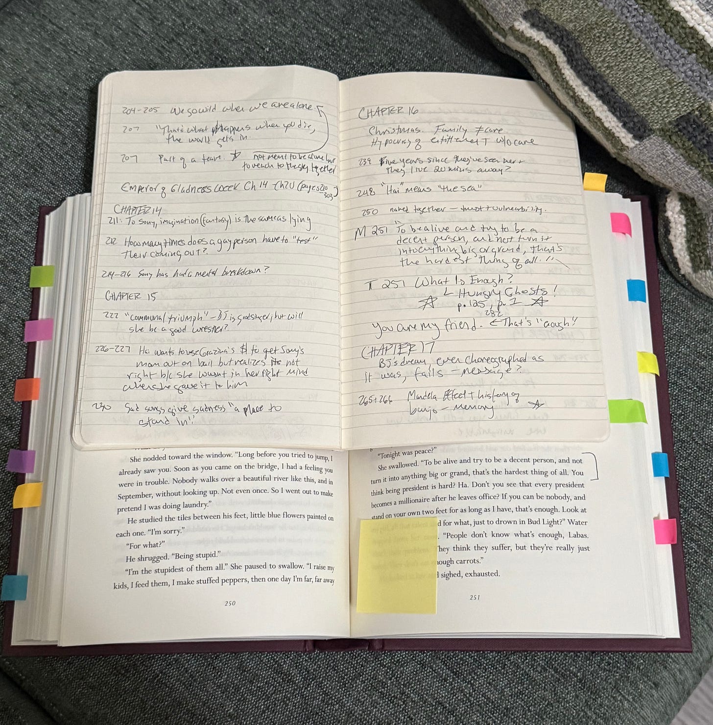 Lined notebook with notes sitting open atop open book.