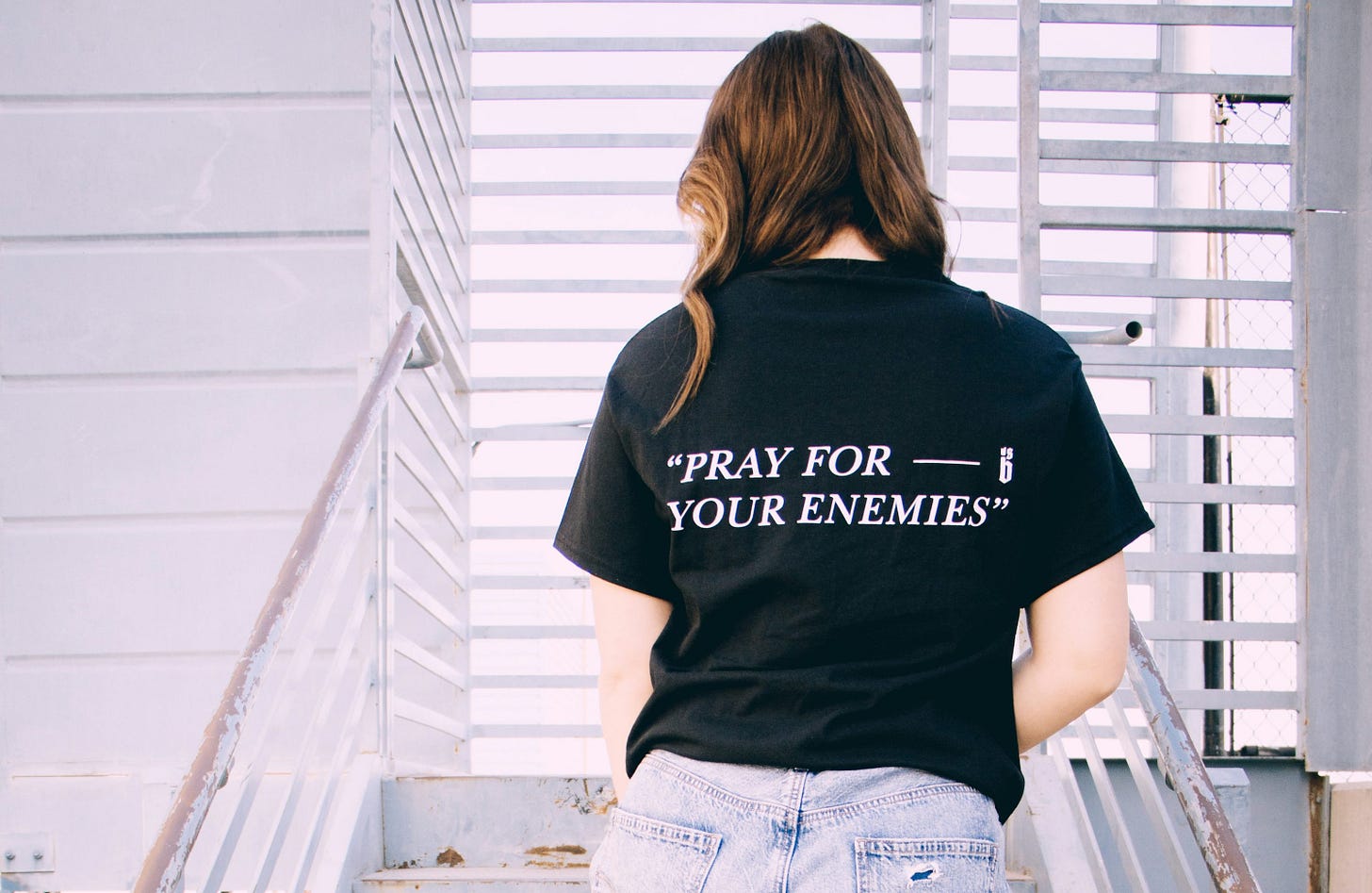 person in black shirt and blue denim jeans standing on gray concrete staircase person in black shirt and blue denim jeans standing on gray concrete staircase