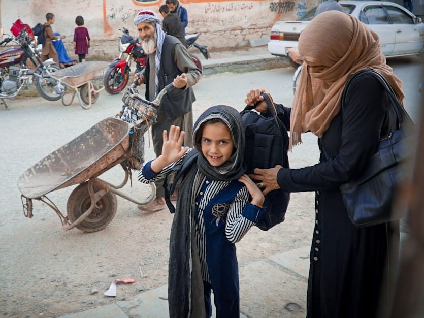 a group of people on a street with a wheelbarrow a group of people on a street with a wheelbarrow