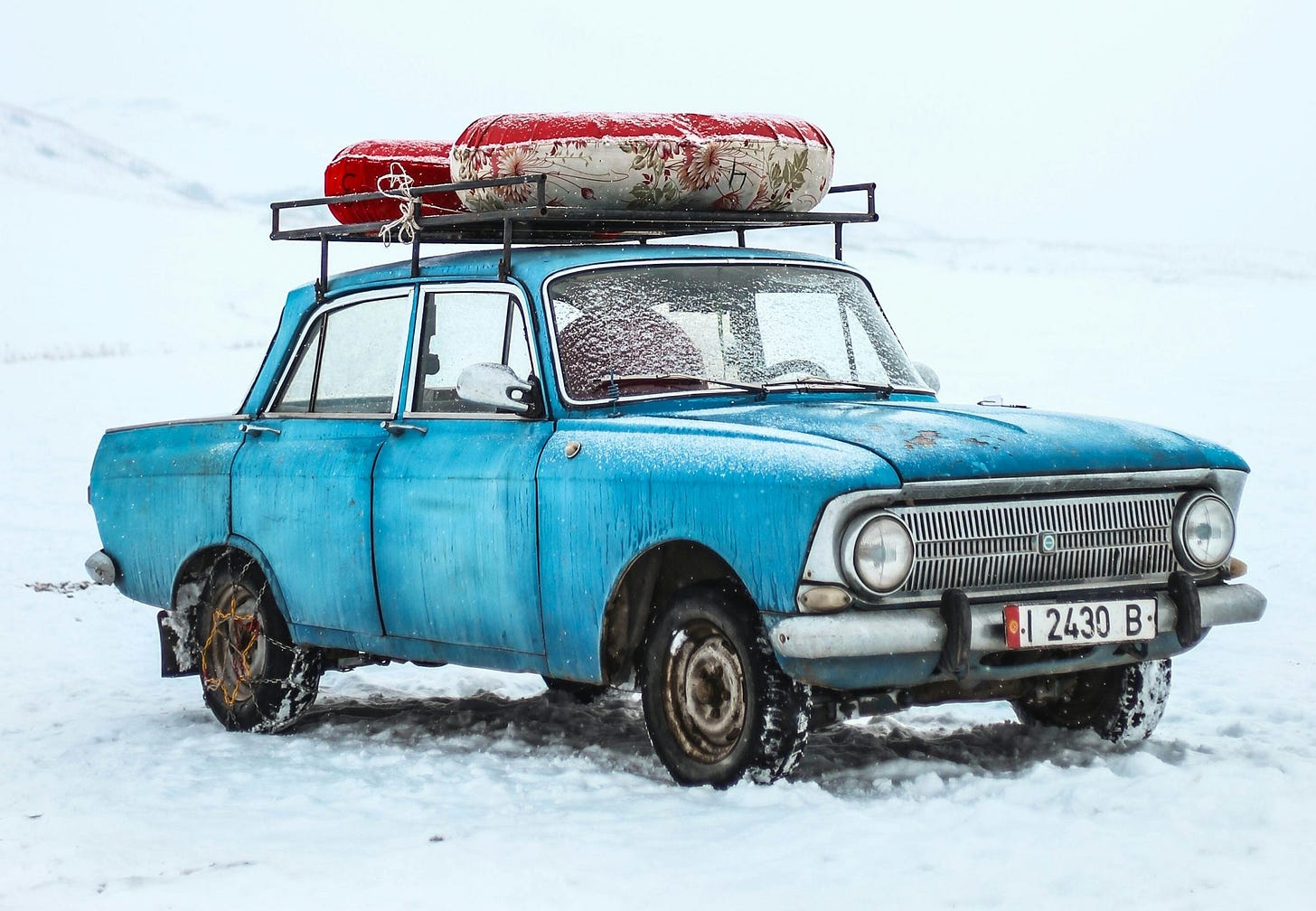 blue sedan on snow ground