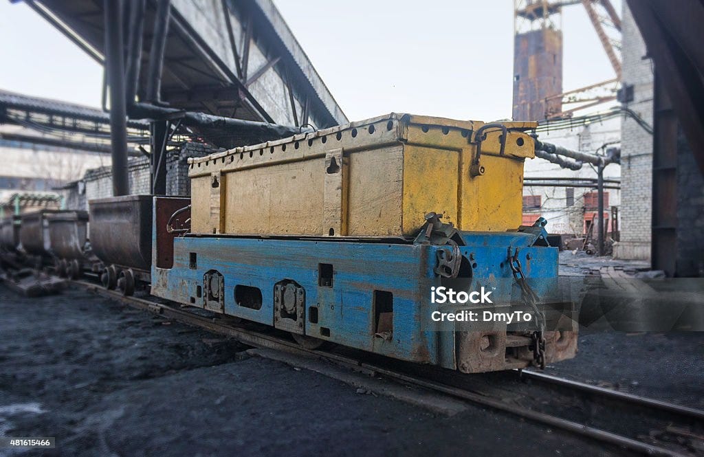 Train in national colors with trolleys in a coal mine - 免版稅旗幟圖庫照片