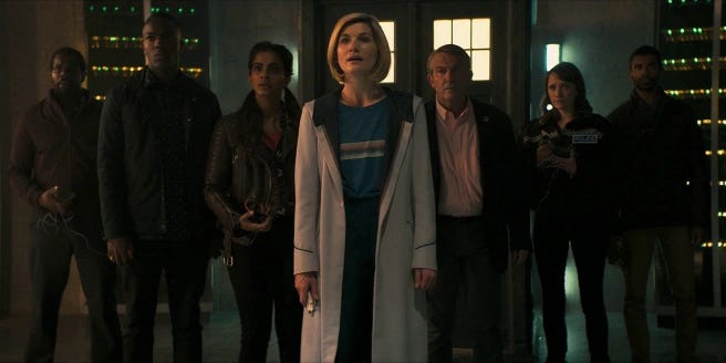 This image from "Resolution" (Doctor Who's 2019 New Year's Day Special) shows Team TARDIS standing in front of the TARDIS, which has materialized inside Britain's General Communications Headquarters (GCHQ), to confront the offscreen Reconnaissance Dalek. From left to right: Aaron Sinclair (played by Daniel Adegboyega), Ryan Sinclair (played by Tosin Cole), Yasmin "Yaz" Khan (played by Mandip Gill), the Thirteenth Doctor (played by Jodie Whittaker), Graham O'Brien (played by Bradley Walsh), Lin (played by Charlotte Ritchie), and Mitch (played by Nikesh Patel). This image from "Resolution" (Doctor Who's 2019 New Year's Day Special) shows Team TARDIS standing in front of the TARDIS, which has materialized inside Britain's General Communications Headquarters (GCHQ), to confront the offscreen Reconnaissance Dalek. From left to right: Aaron Sinclair (played by Daniel Adegboyega), Ryan Sinclair (played by Tosin Cole), Yasmin "Yaz" Khan (played by Mandip Gill), the Thirteenth Doctor (played by Jodie Whittaker), Graham O'Brien (played by Bradley Walsh), Lin (played by Charlotte Ritchie), and Mitch (played by Nikesh Patel).